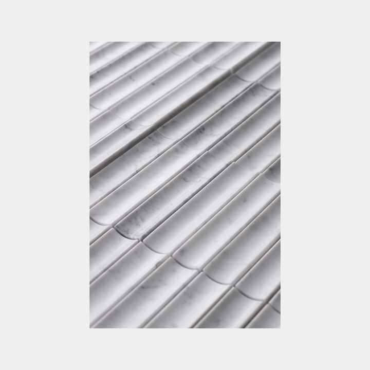 Close-up of inverted flute marble tile surface in White Carrara