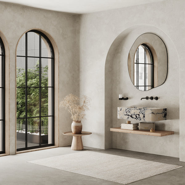 Raya Ribbed Marble Basin wall-mounted in minimalist bathroom interior with arched window and natural decor accents